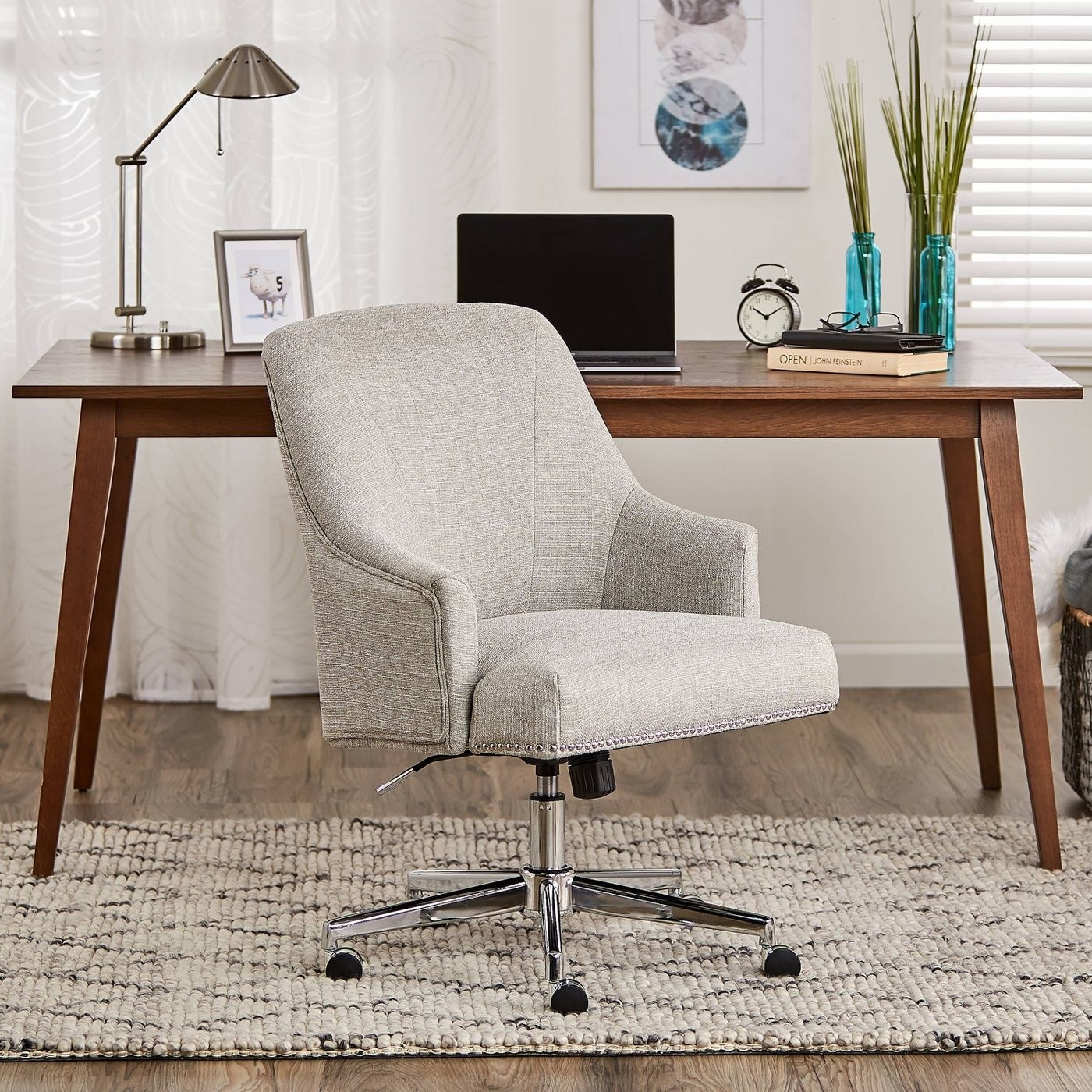 An upholstered swivel office chair in front of a desk