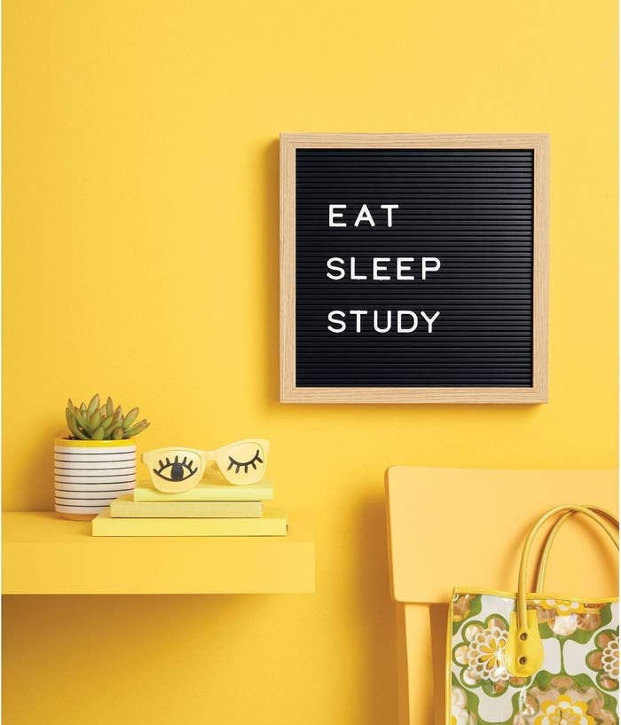black letterboard with white letters spelling out &quot;eat, sleep, study&quot; hanging on a yellow wall