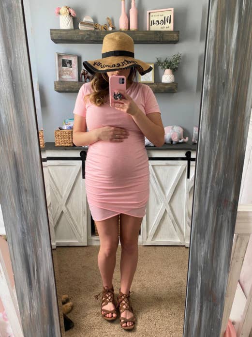 pregnant reviewer wearing pink dress with sandals