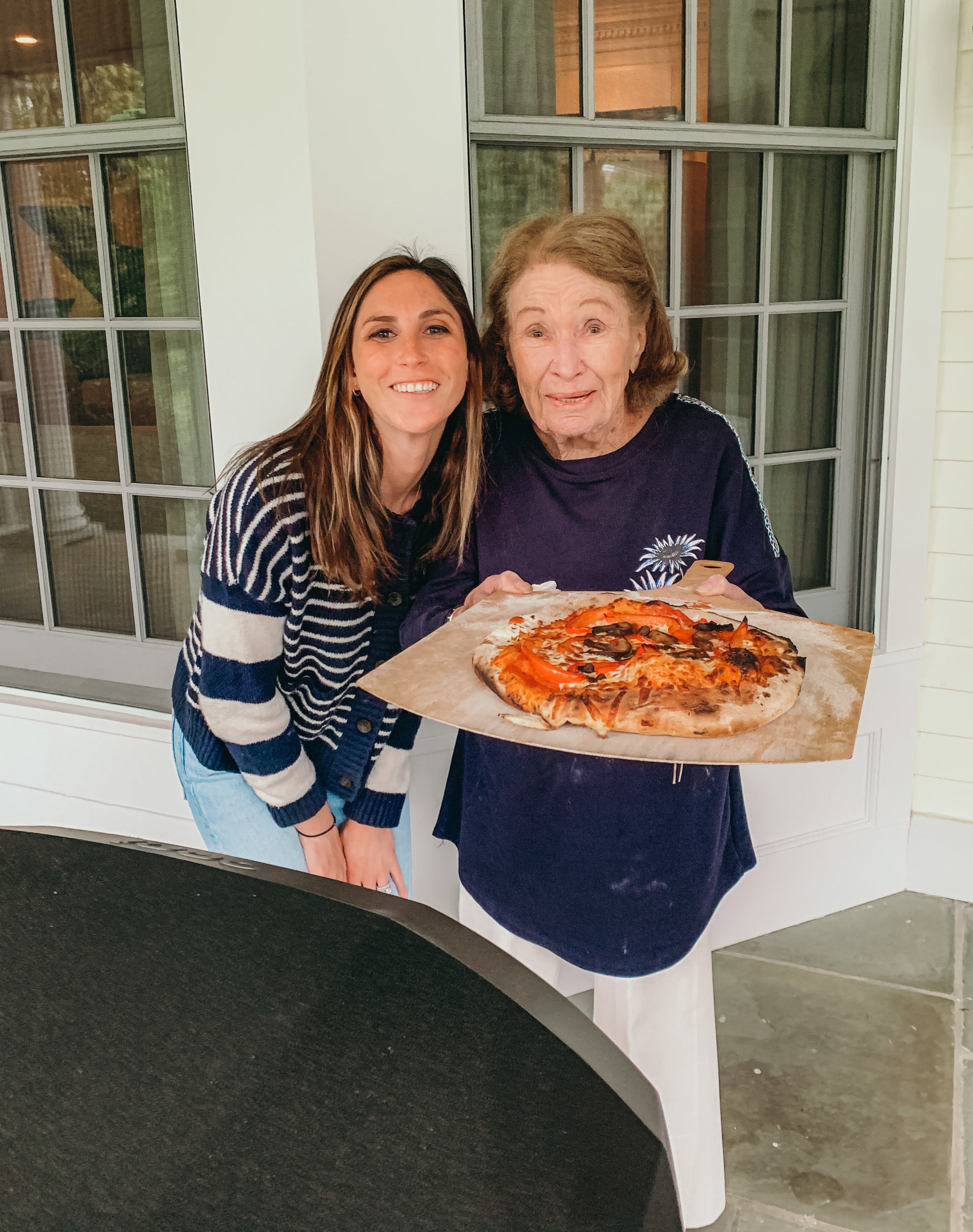 Me and my grandmother smiling with her pizza pie