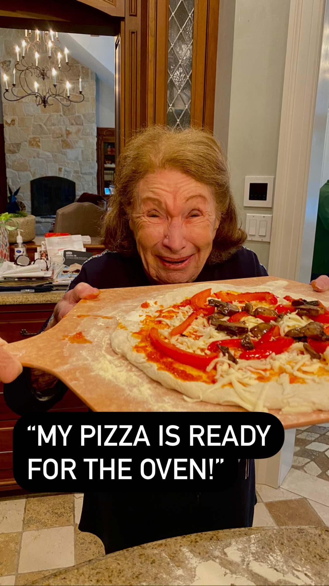 Grandma holding up her ready-to-bake pizza