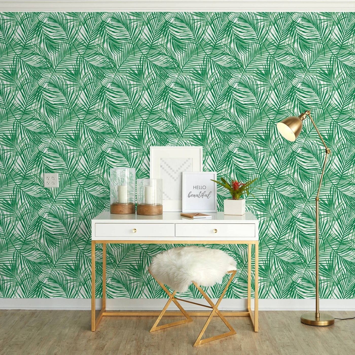 green tropical themed peel and stick wallpaper on a wall behind a white and gold desk and stool