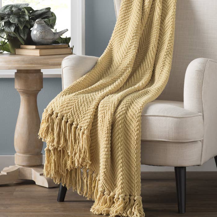 Yellow blanket draped over accent chair