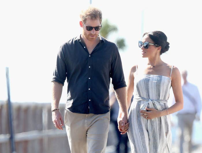 Prince Harry (L) and Meghan Markle walk along the picturesque Kingfisher Bay Jetty