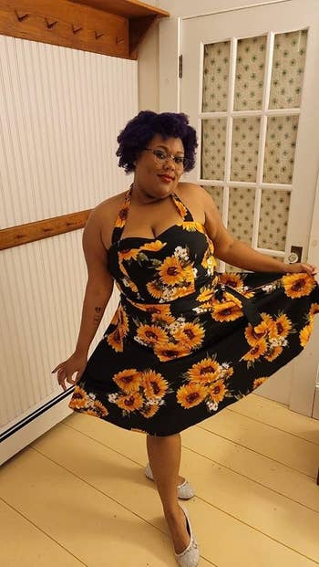 reviewer wearing the dress in black with a sunflower print