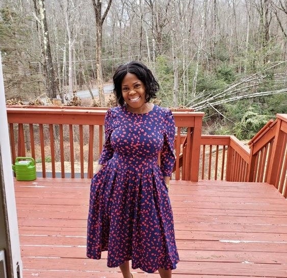 Reviewer wearing the dress in blue and purple floral print