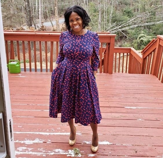 Reviewer wearing the dress in blue and purple floral print