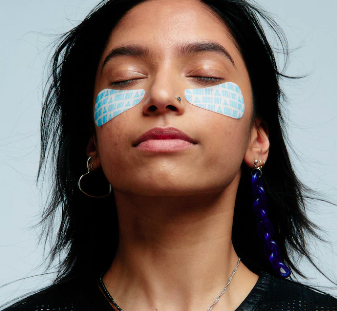 A person wearing the eye masks; their eyes are closed and they look blissful