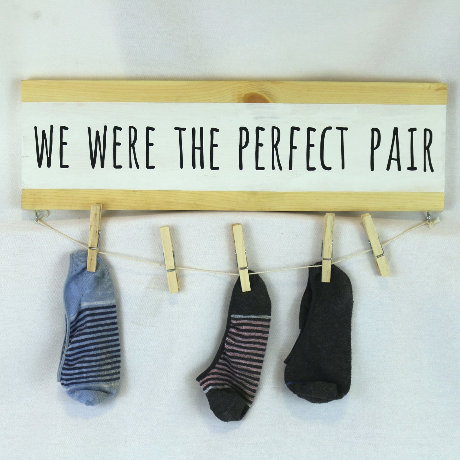 the sign that says we were the perfect pair with socks hanging from it