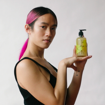 Model holding bottle of soap 