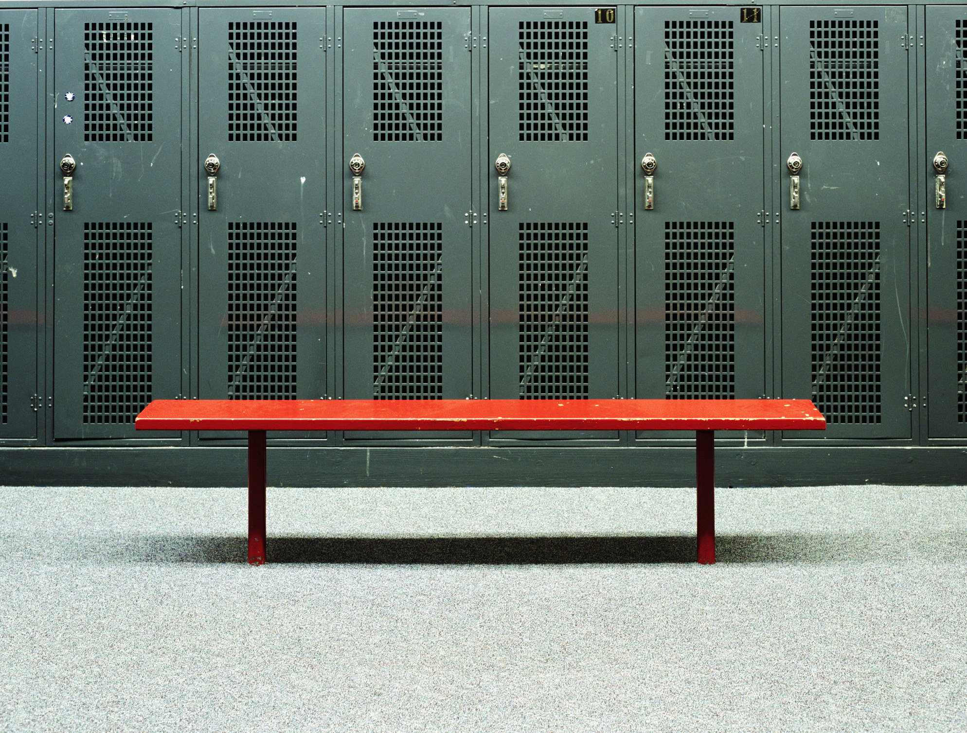 An empty bench in front of lockers