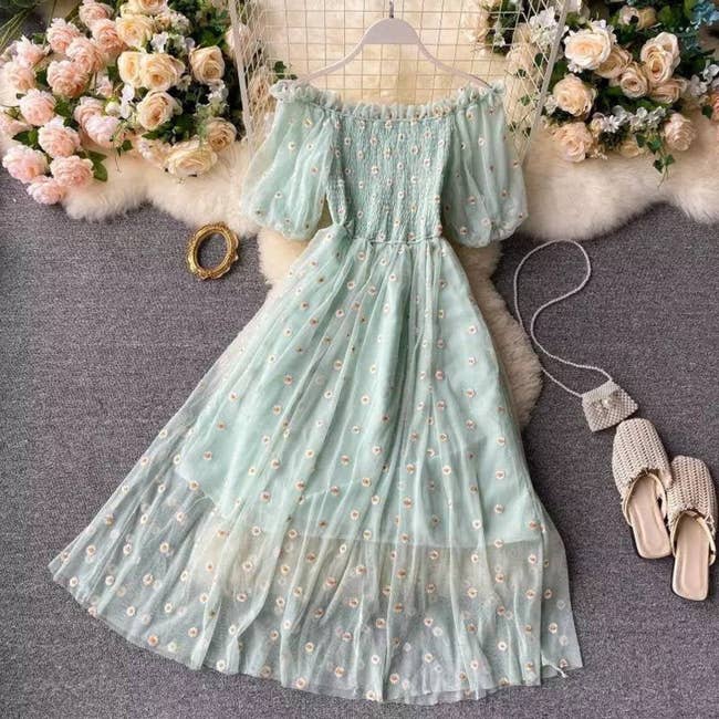 Off-the-shoulder light-green dress with puffy sleeves and a sheer overlay with embroidered flowers on it