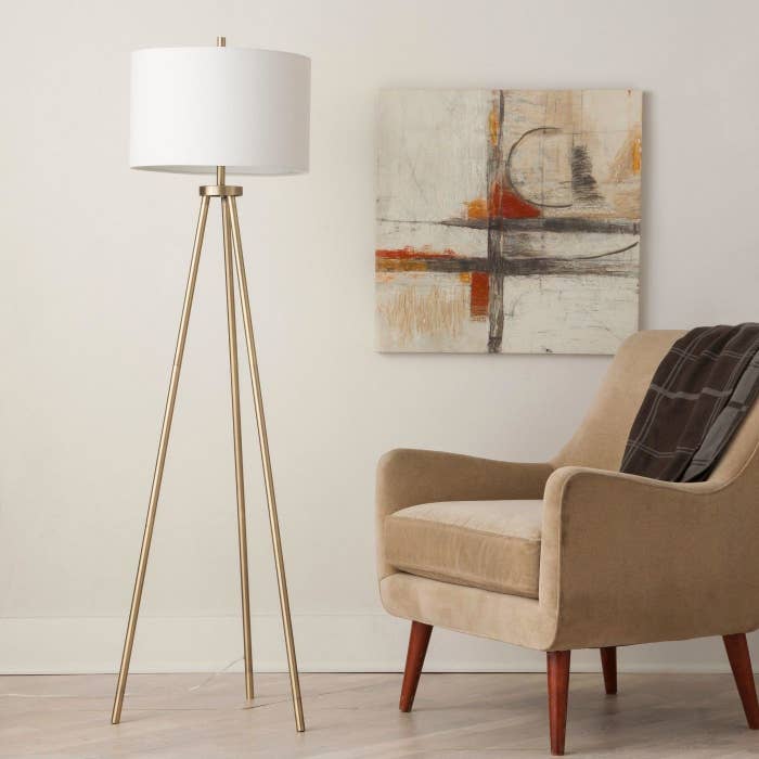 A gold tripod lamp in a home