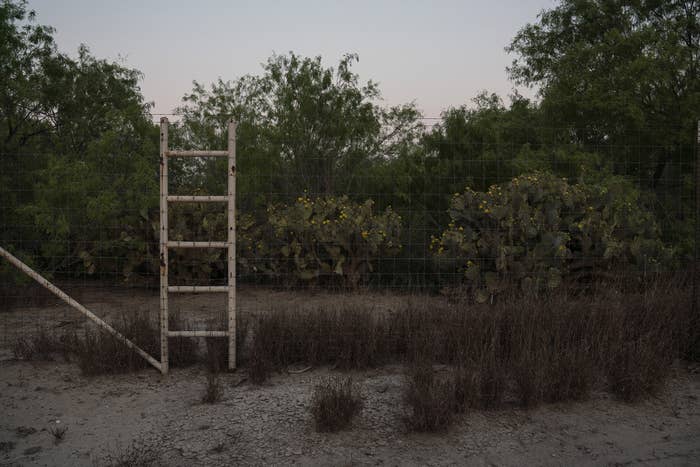 A wire fence in the desert with a white ladder built into it