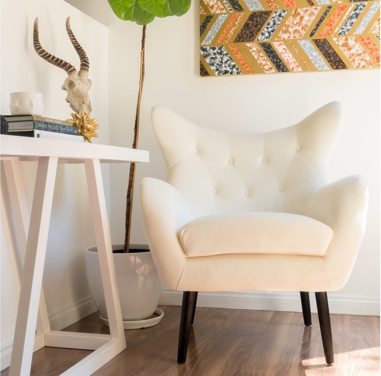 An ivory velvet accent chair in a living room corner
