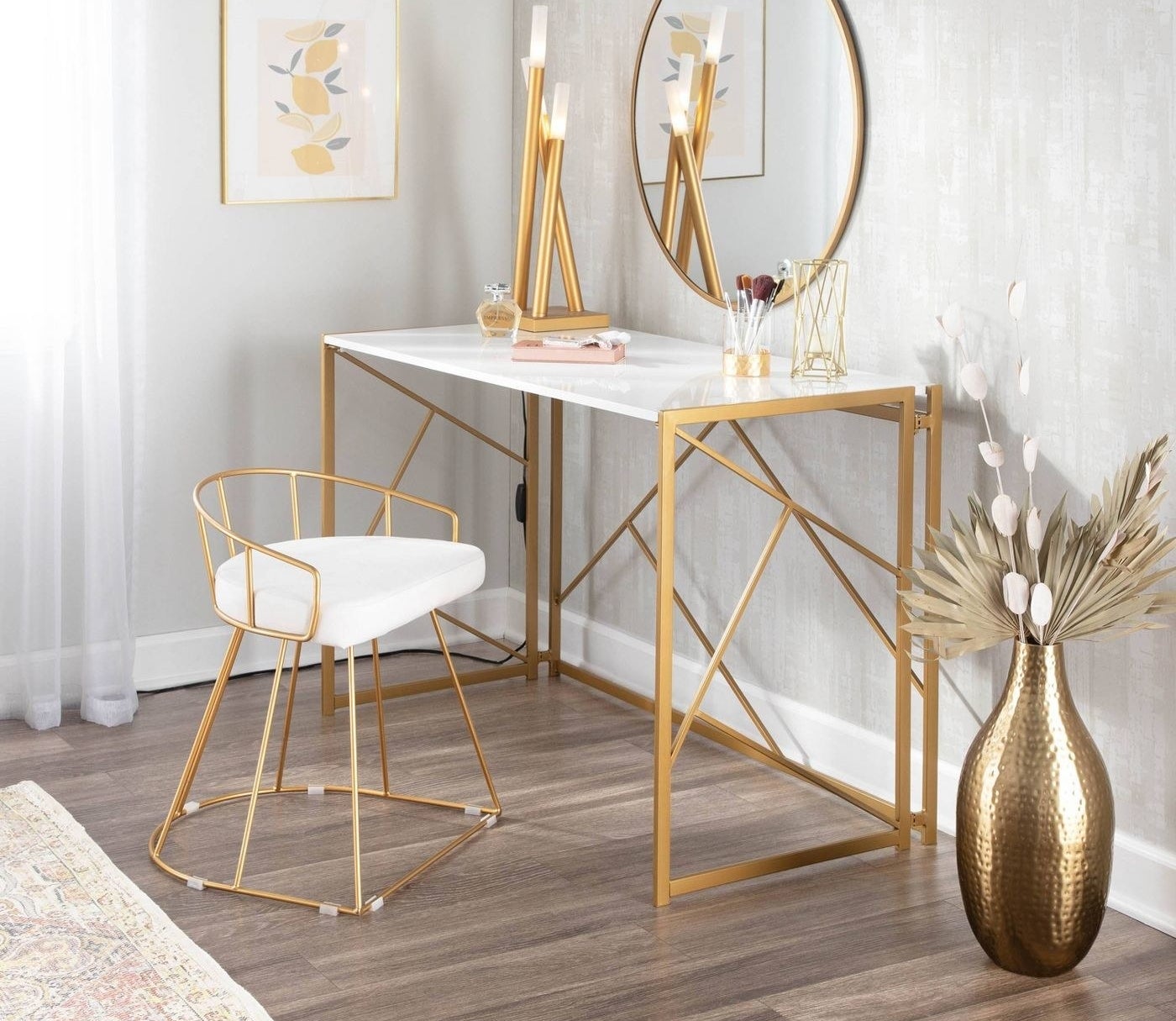 The desk has a white top and a gold geometrical backing and legs  
