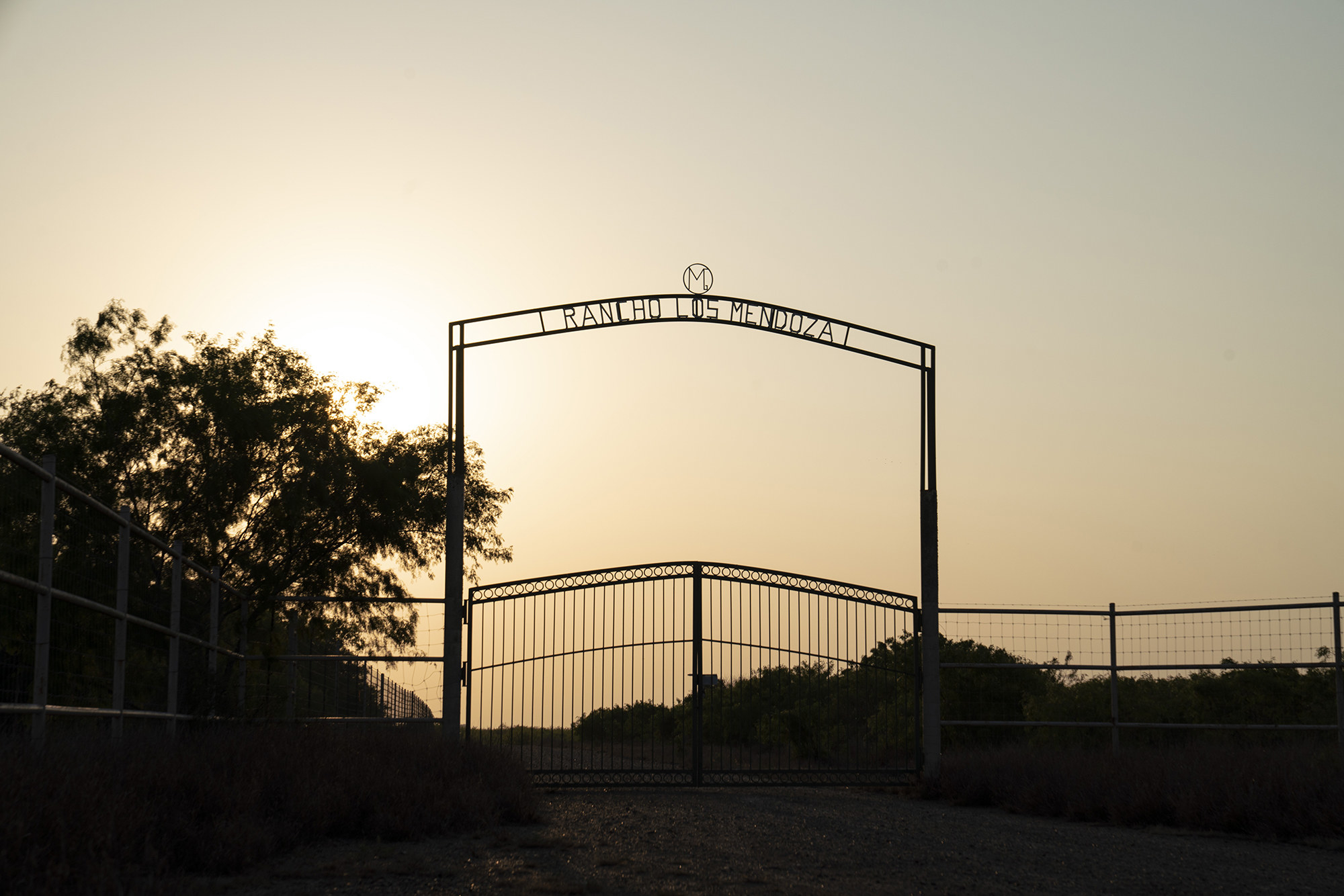 A large iron fence with a sign that reads Rancho Los Mendoza