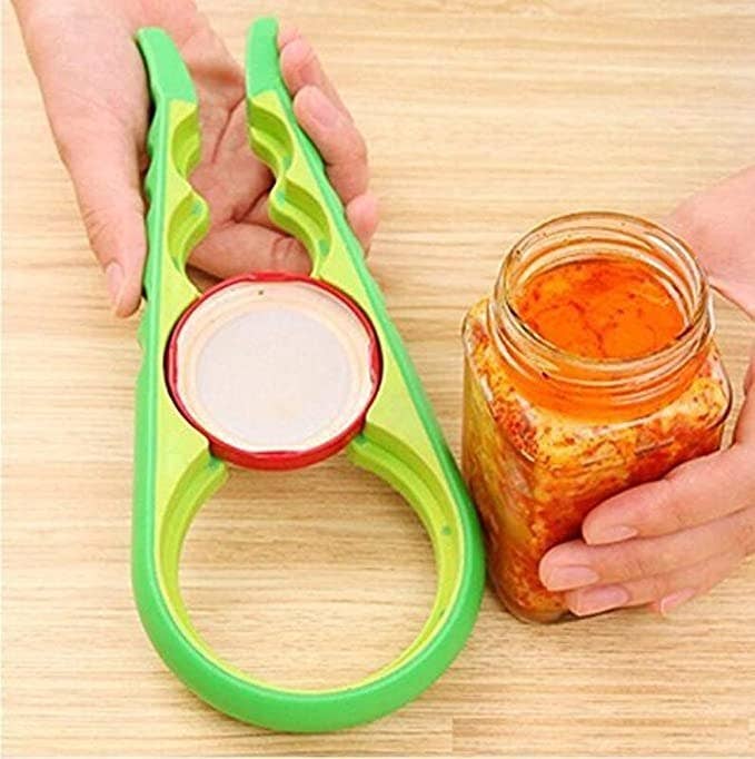 Person holding the jar opener next to an open jar.