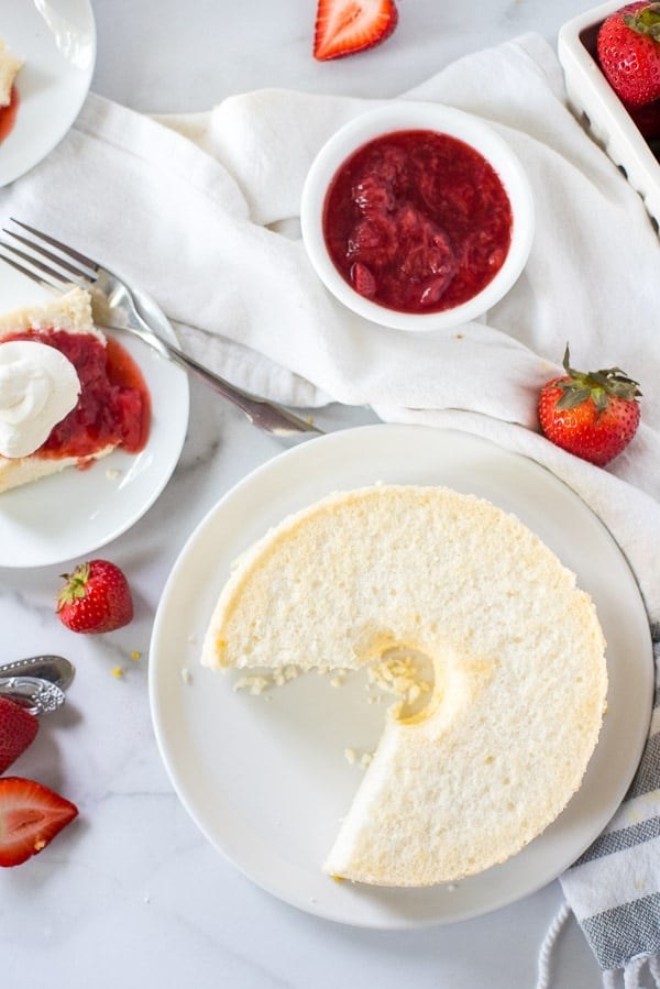 An angel food cake with fresh strawberry topping.