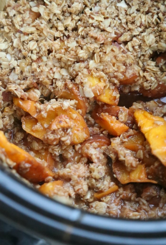 A slow cooker full of peach crisp.