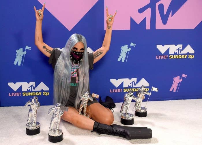 Lady Gaga posing with her Moonmen awards at the VMAs