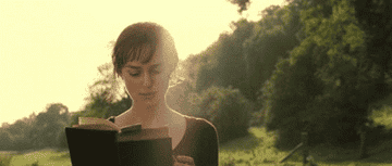 Elizabeth Bennet reading a book as she walks in the field 