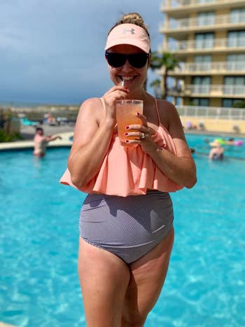 Reviewer wearing the bikini set with peach ruffled top and blue gray striped bottoms