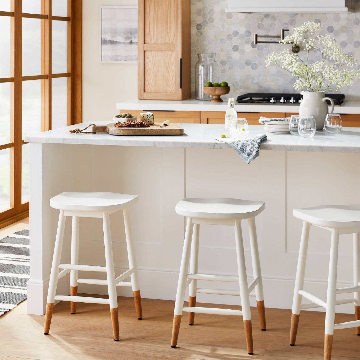 white counterstools with curved saddle seats next to a counter