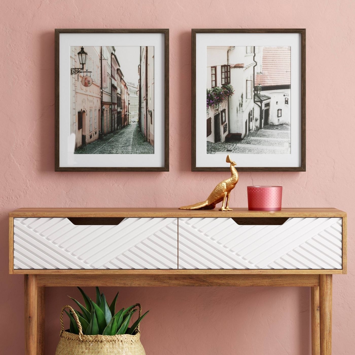 two framed city photographs on a pink wall