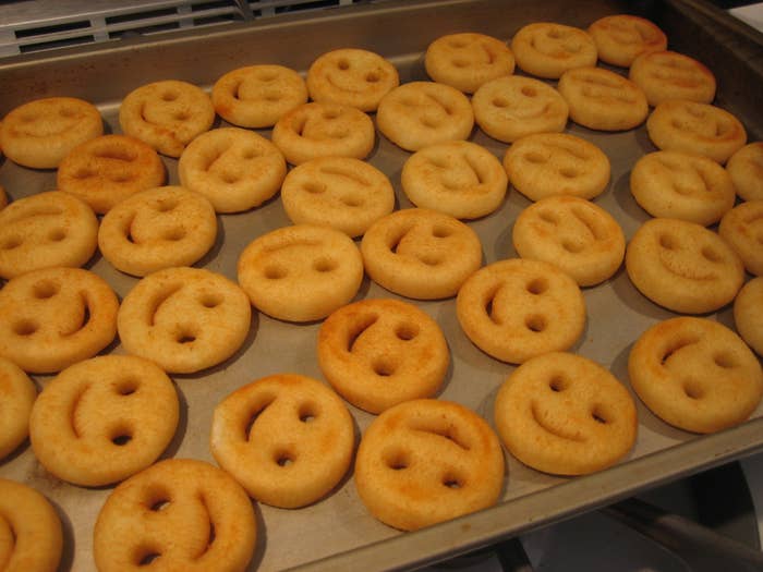 Potato Smiles spread out on an oven tray