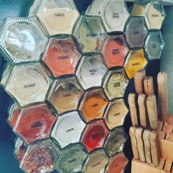 Dozens of the magnetic, glass spice containers on a reviewer's fridge 