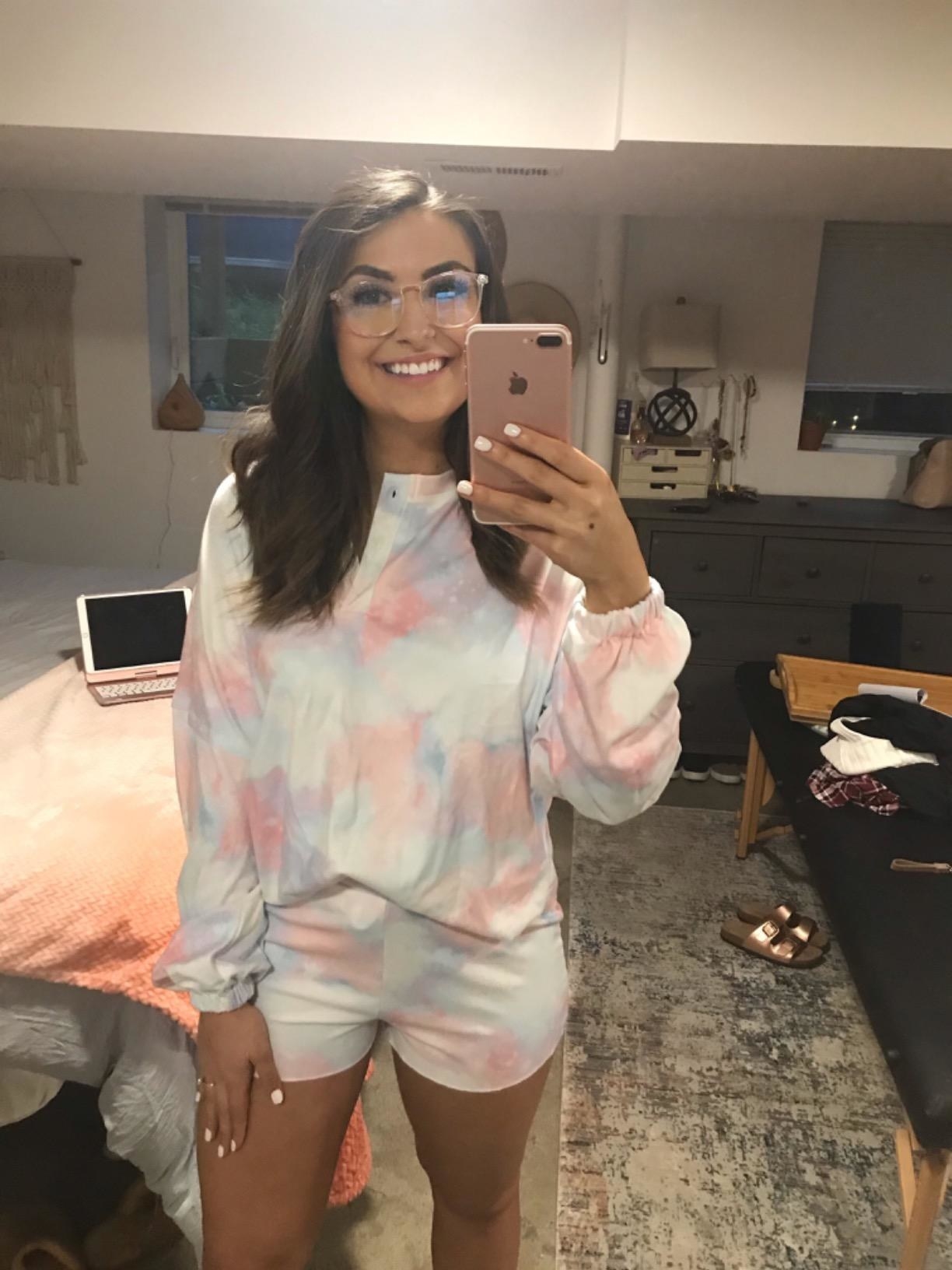 reviewer smiles while wearing matching tie dye long sleeve top and shorts 