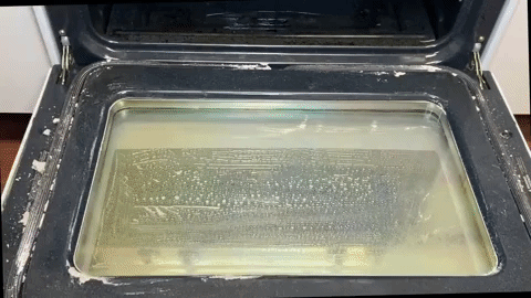 Gif of model using towel to wipe up oven scrub