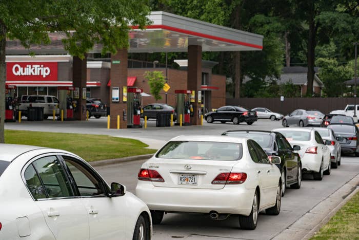 A long of cars of people waiting to get gas