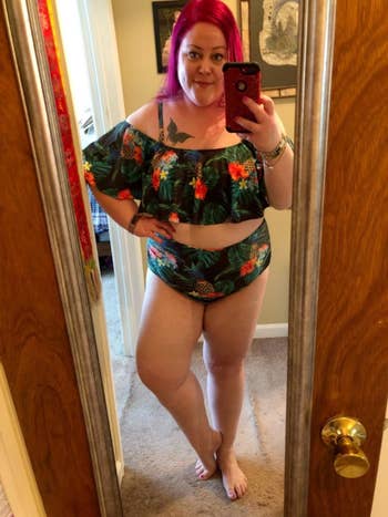 Reviewer wearing the green and red floral ruched two-piece with flounce detail
