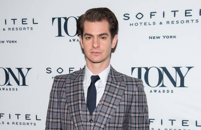 Andrew Garfield posing on a red carpet in a suit