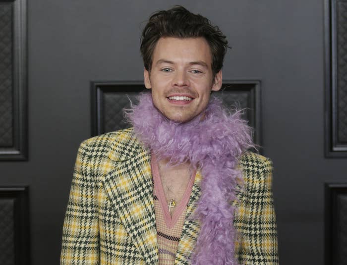 Harry wears a yellow jacket and purple furry scarf