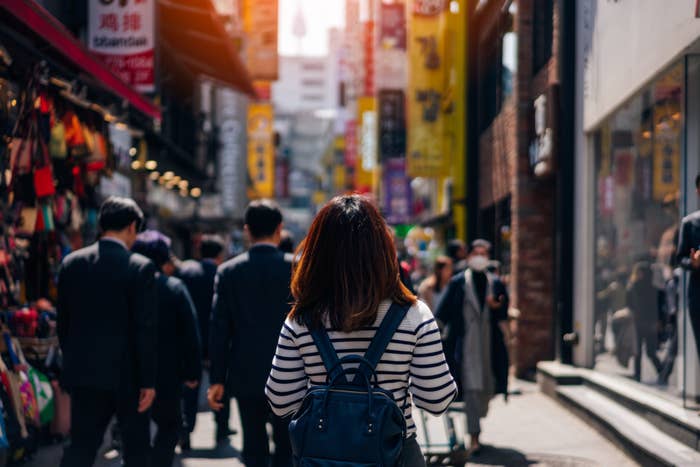 Back of young Asian woman in Myeongdong street market at Seoul, South Korea.