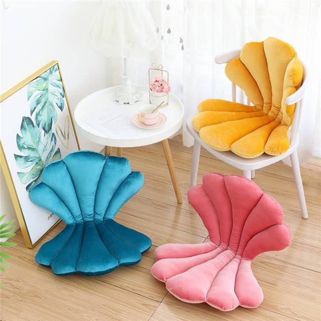 A velvet pillow that's opened like a clam-style seashell so it provides back and butt support. It's in three colors: blue, pink, and yellow