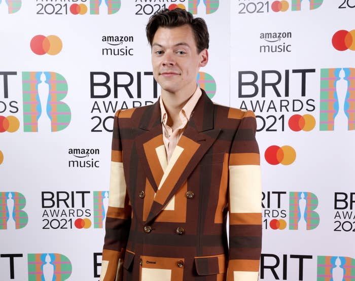 Harry wears a brown and orange geometric-print suit jacket to the awards show