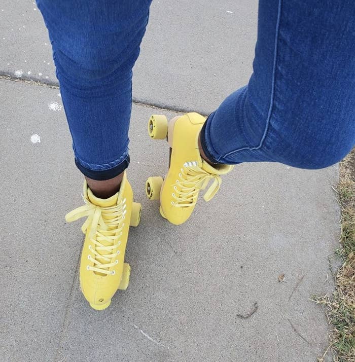 A person wearing pastel yellow roller skates