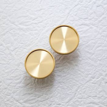 two brass knobs on a white background