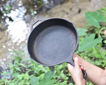 Model holding a cleaned cast iron pan