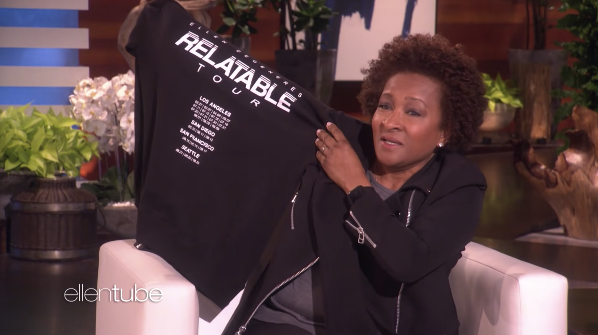 Wanda Sykes appearing on The Ellen Show and holding up a tour T shirt