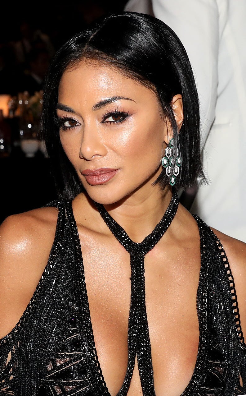 Nicole Scherzinger wears a deep-cut black beaded dress with her hair in a short cropped cut