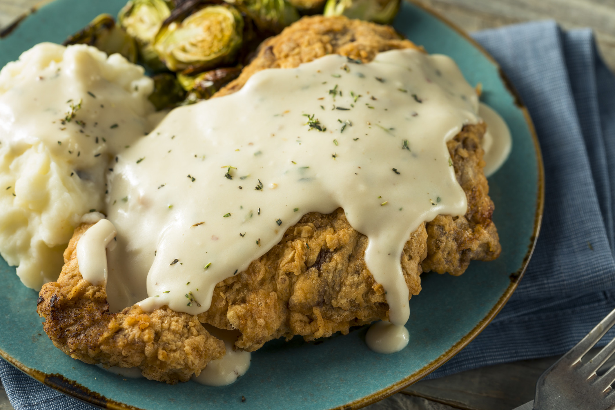 Country fried steak with gravy and mashed potatoes.