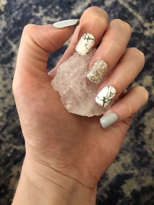 hand with various gray, marble print, and glitter design press on nails