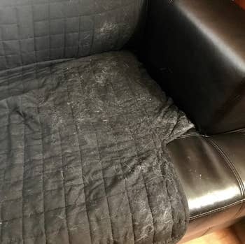 reviewer's black furniture cover with lots of white cat hair on it