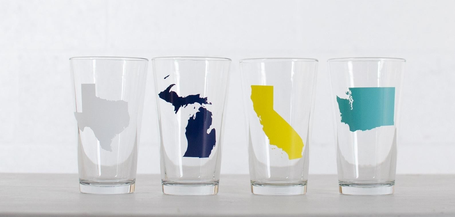 clear pint glasses with illustration of texas, michigan, florida, and washington on them