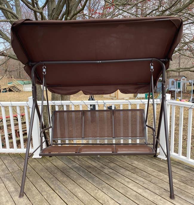 Reviewer photo of their glider in brown on a porch